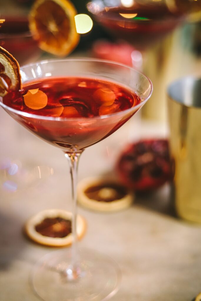 A pomegranate martini with sparkles and orange.