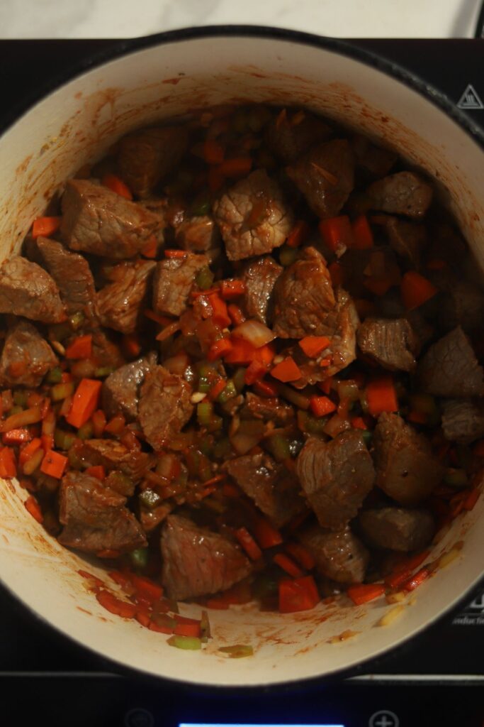 Beef added to the Dutch oven with veggies.