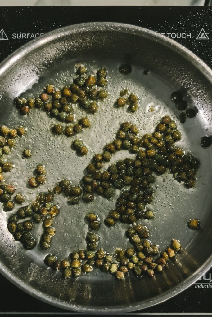 Capers in a frying pan with oil. 