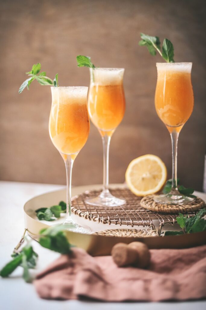 Three bellinis garnished with mint. 