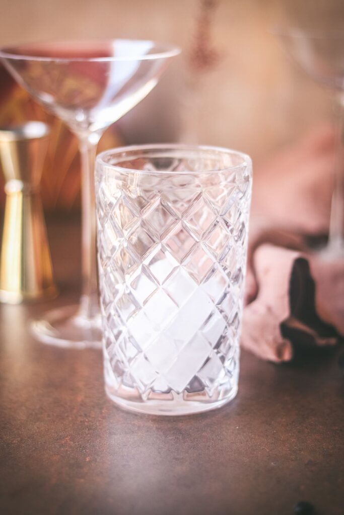 A cocktail shaker half filled with ice. 