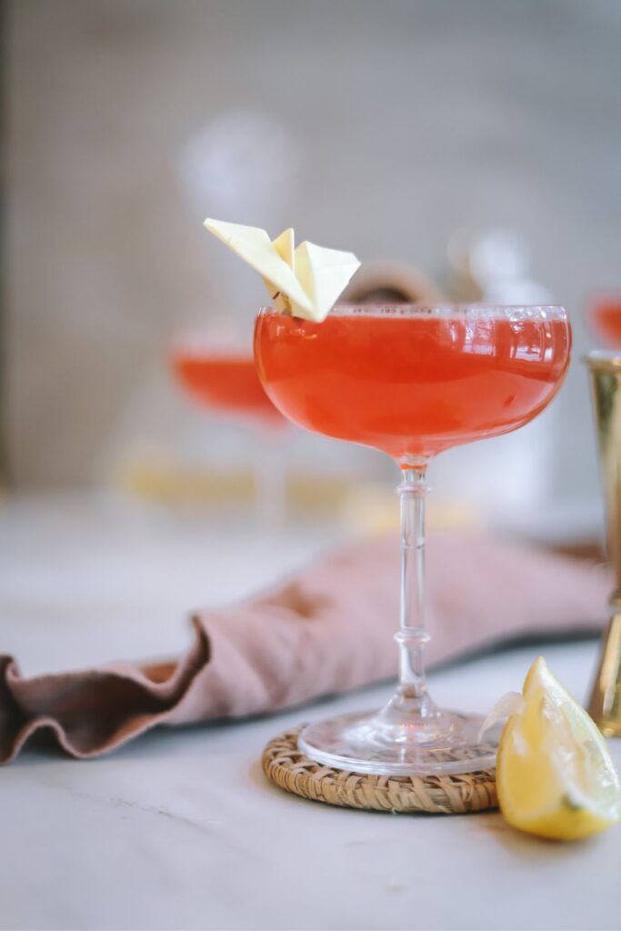 A paper plane cocktail with a small yellow plane for garnish. 