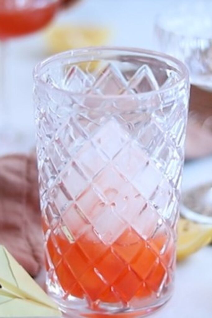 Cocktail shaker with lemon, aperol and ice. 