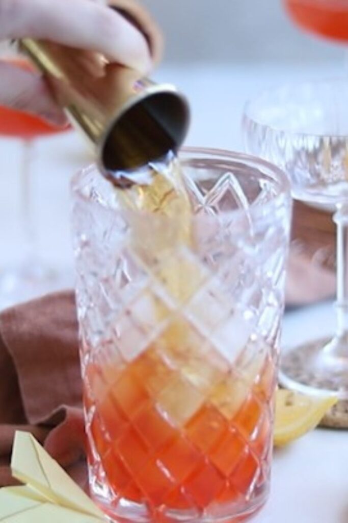 Cocktail shaker with lemon, aperol, amaro nonino, bourbon and ice. 