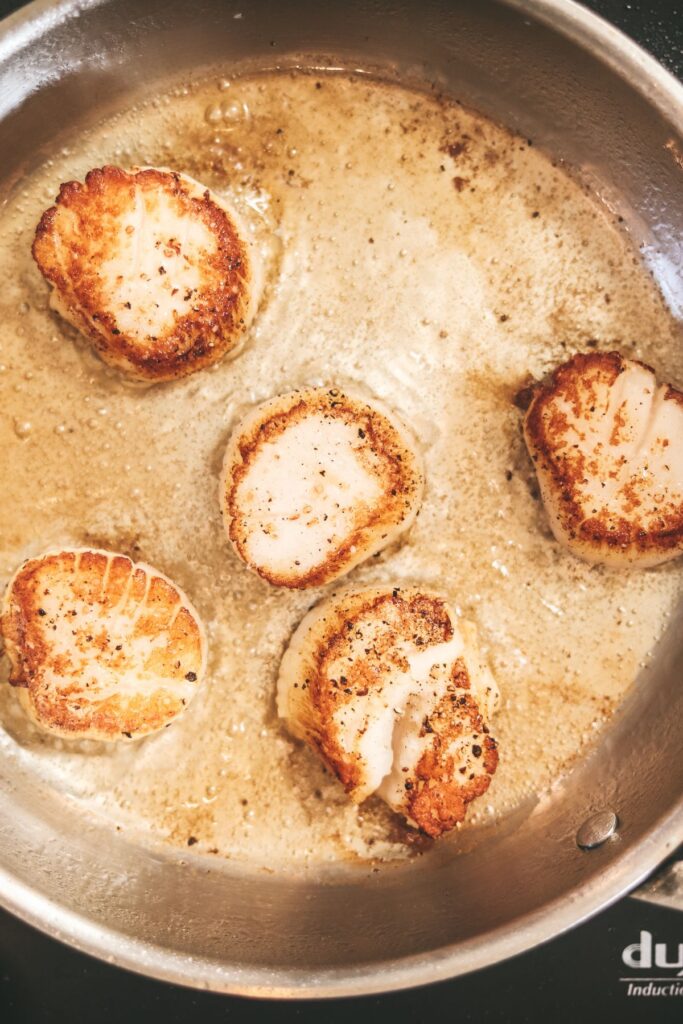 Scallops flipped, searing in olive oil. 
