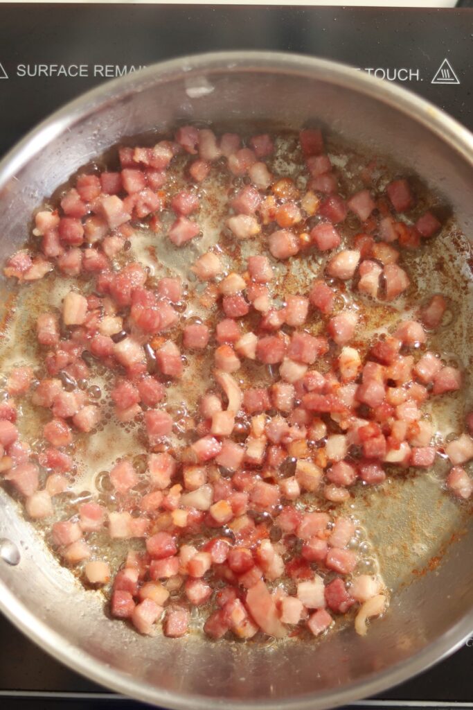Pancetta in a pan, cooked. 