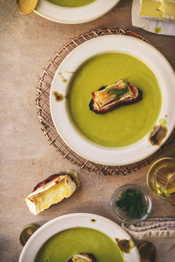 The bowls of asparagus soup with brie crostini and dill. 