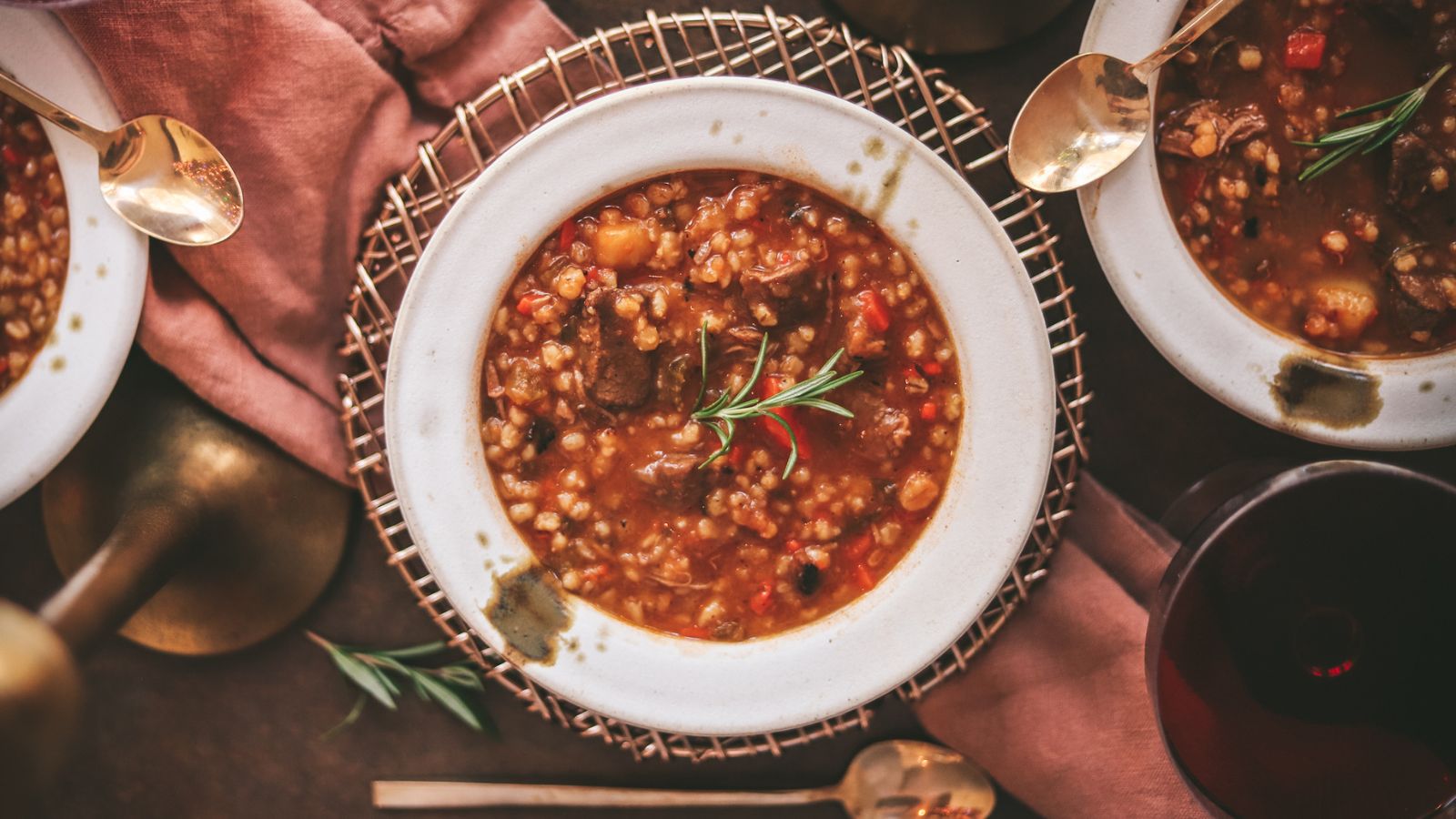  Beef and barley soup with napkins and red wine. 