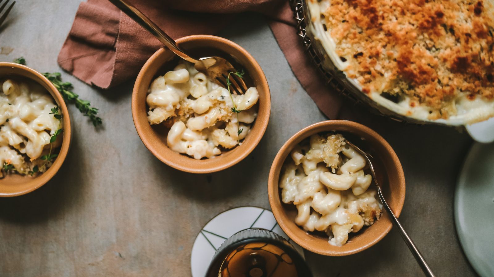 Three bowls of brie mac and cheese with thyme and panko breadcrumbs. 