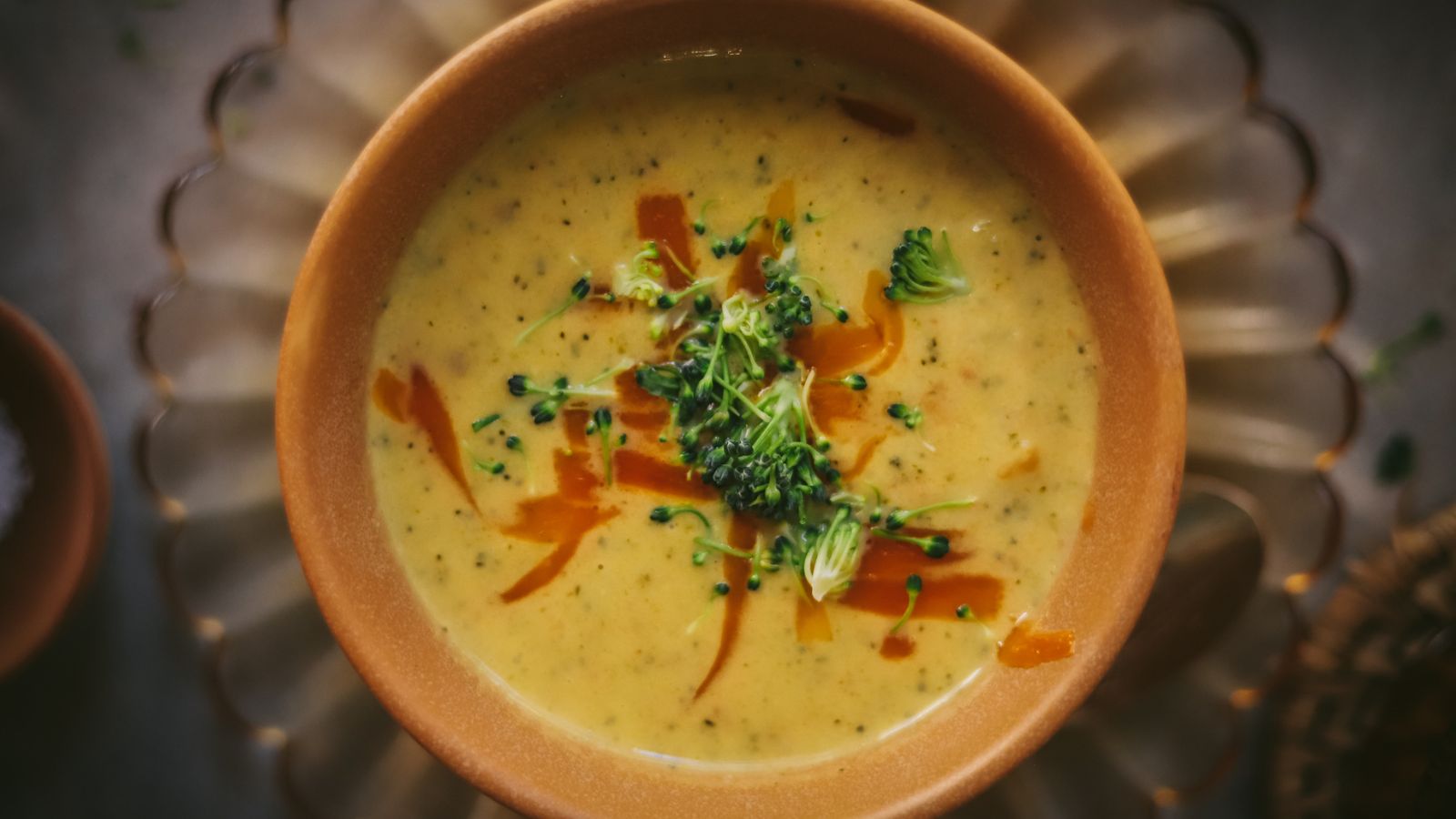 A bowl of Broccoli and cauliflower soup with cheddar cheese. 