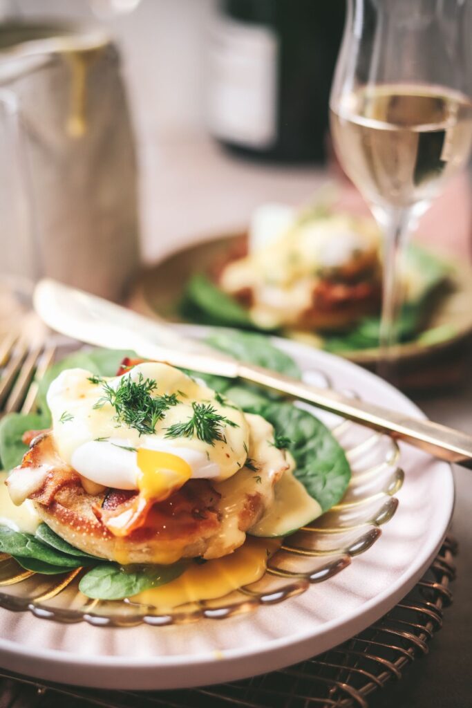 Eggs benedict with champagne and gold cutlery. 