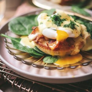 Eggs benedict with a runny yolk and spinach.