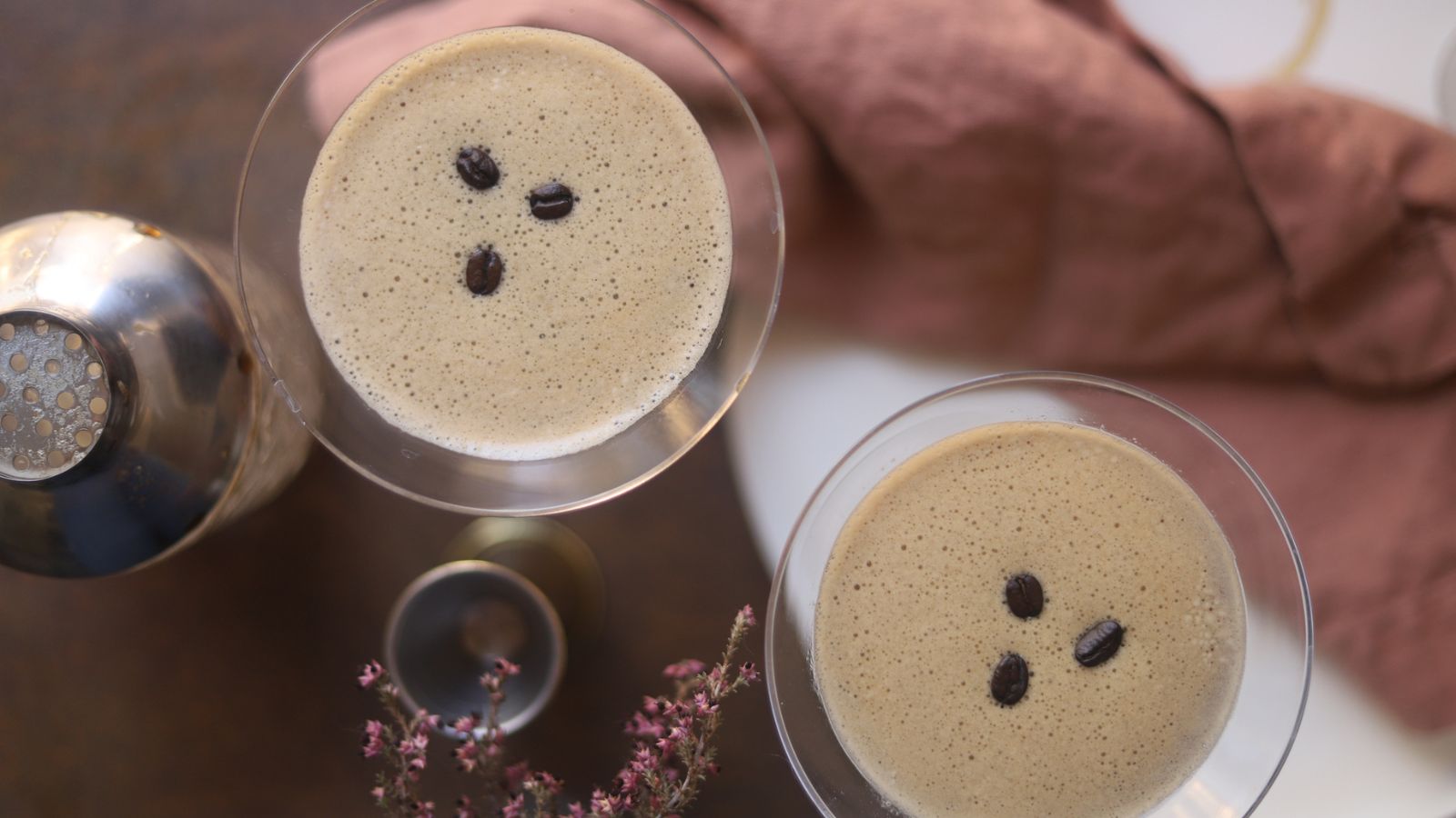 Two espresso martinis garnished with coffee beans. 