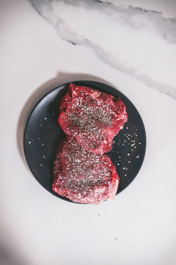 The filets, generously seasoned with salt and pepper. 