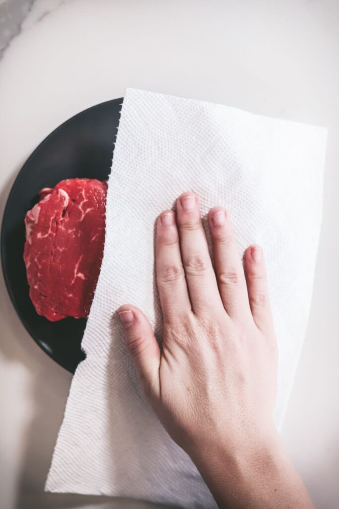 Patting filets down with paper towel to dry the exterior. 