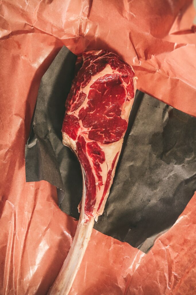 A raw tomahawk steak on butcher paper. 