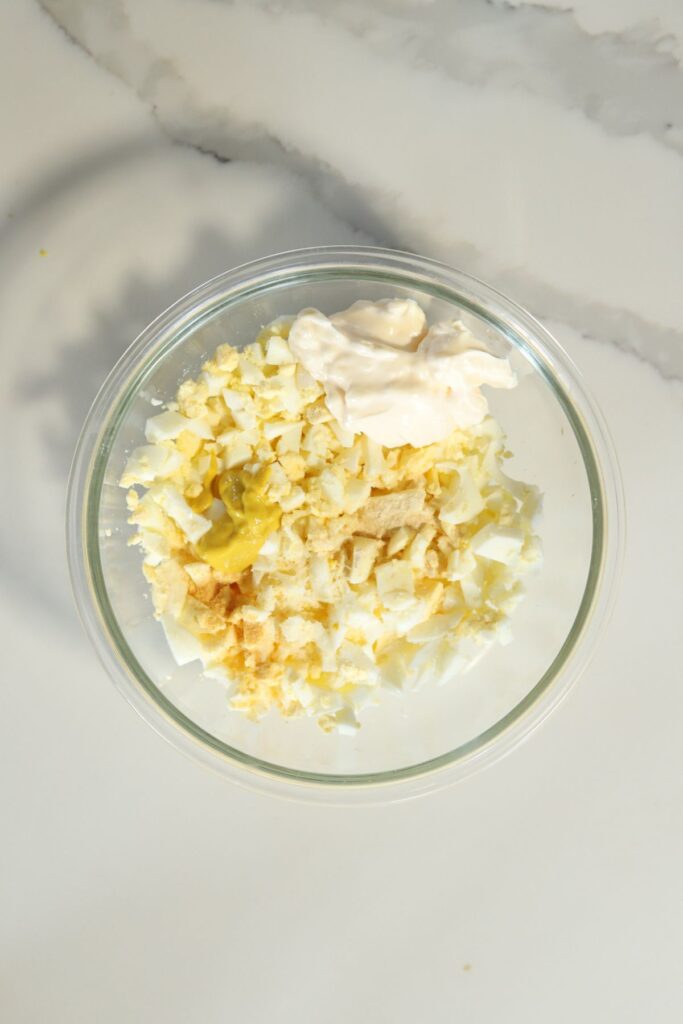 Eggs, mayo, mustard, garlic and onion powder in a bowl. 