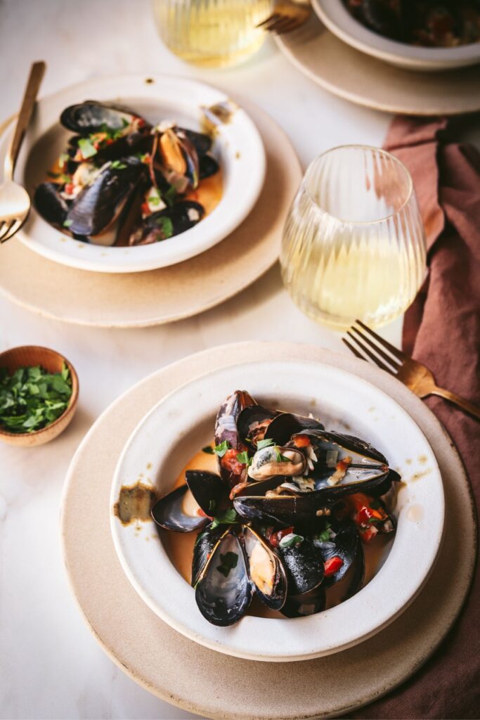 Bowls full of white wine mussels with parsley