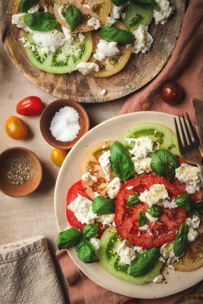 Two Caprese salads, with salt pepper and cherry tomatoes. 