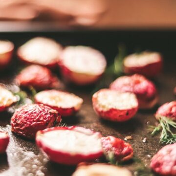 A side view of the roasted radishes on a baking sheet.