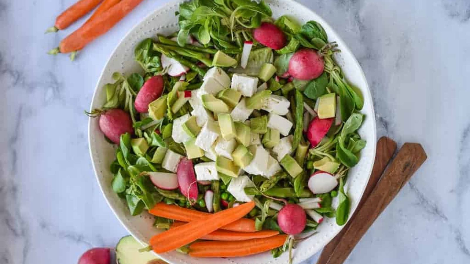 A green salad with radish, asparagus, and carrots. 