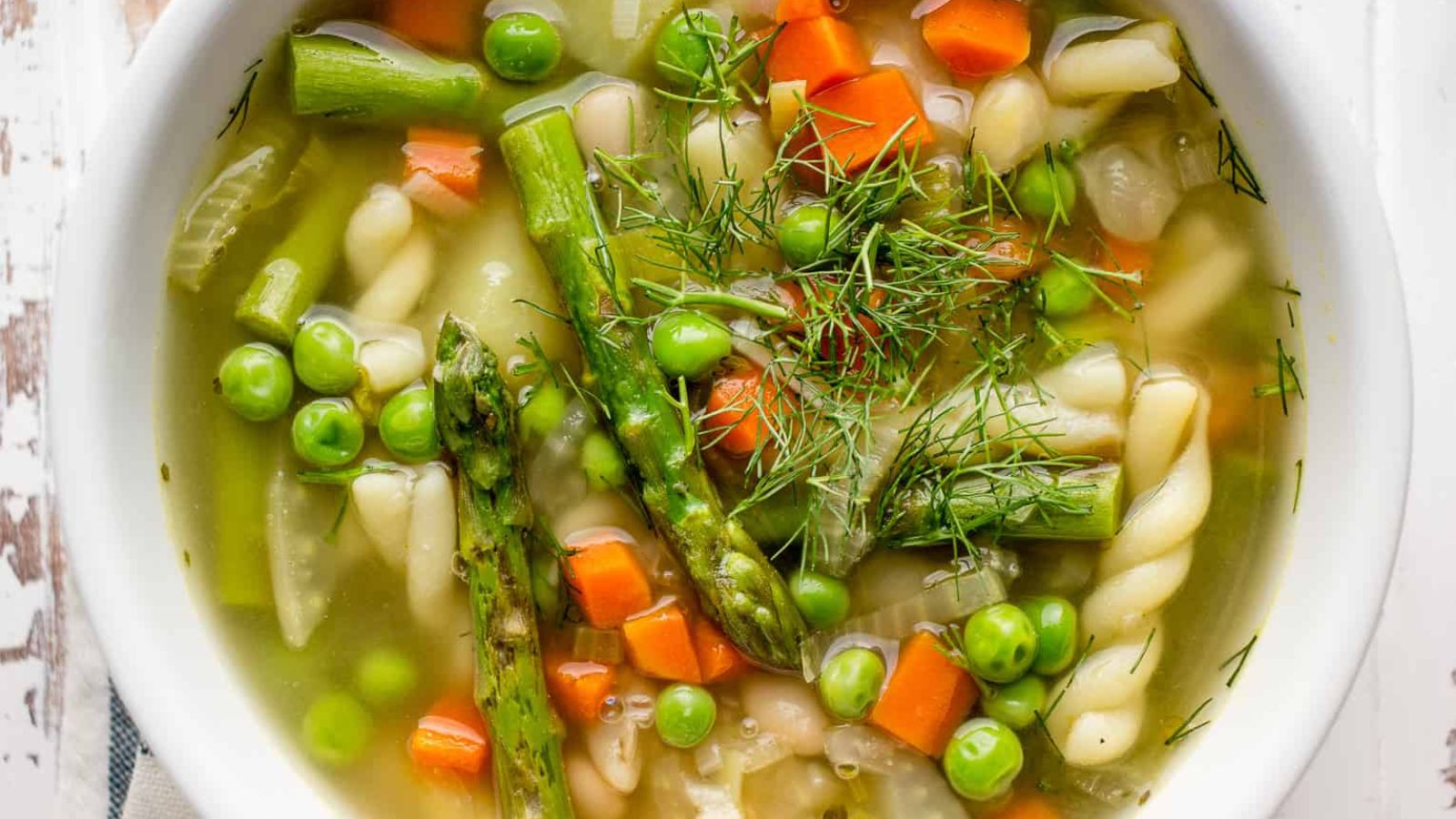 Minestrone soup with asparagus, peas and dill. 