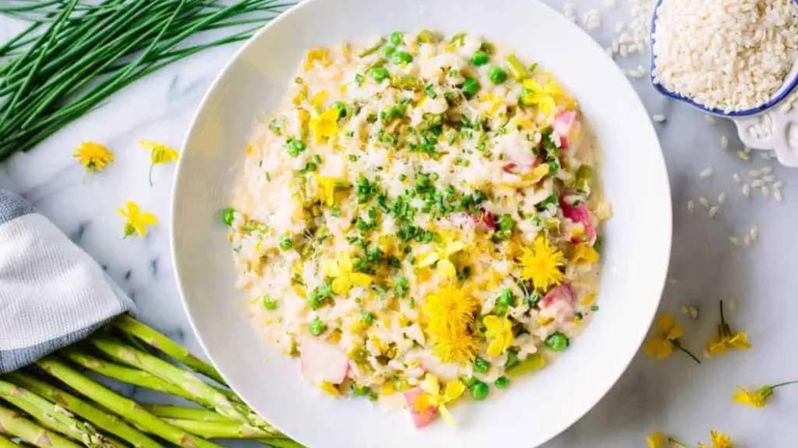 A bowl of spring risotto with asparagus and flowers. 