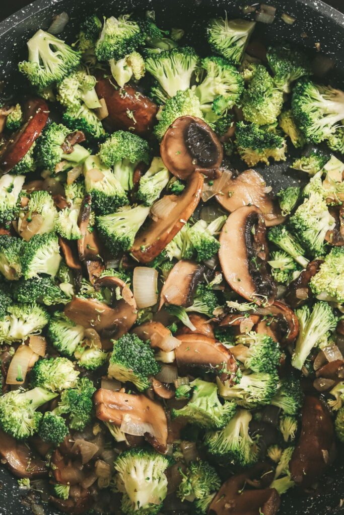 Cooking broccoli in the mushroom mix. 