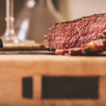 A sliced Denver steak on a cutting board.