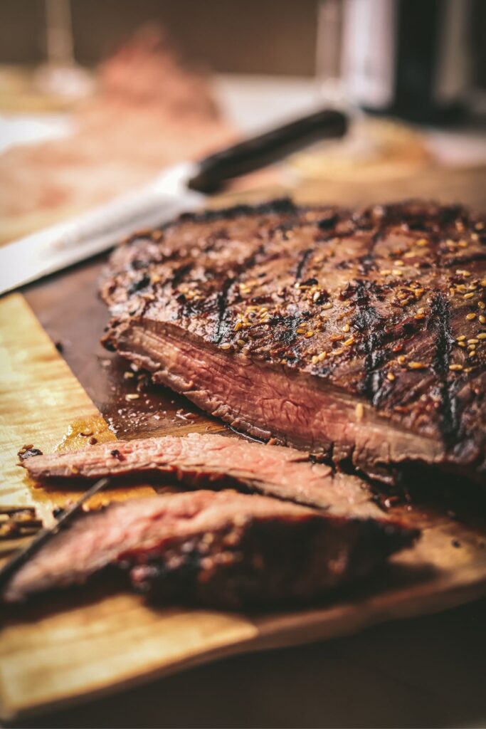 Flank steak on a cutting board, sliced. 