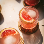 A paloma on a woven coaster garnished with grapefruit.