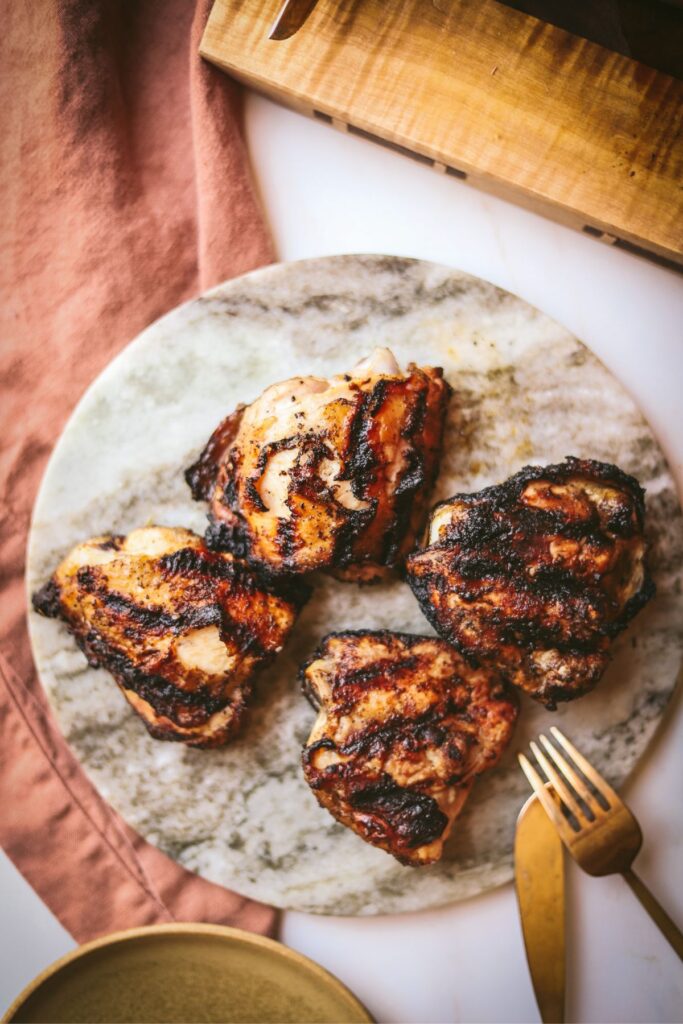 Grilled chicken thighs with gold cutlery. 