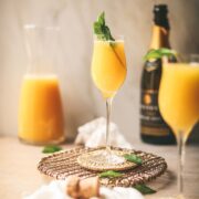 Two mimosa mocktails with mint and non-alcoholic sparkling wine.