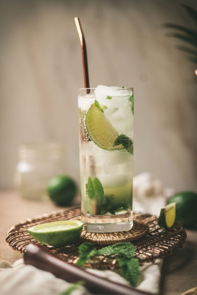 A virgin mojito with limes mint and a muddler. 