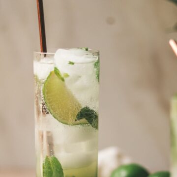 Two mojito mocktails with limes and mint.
