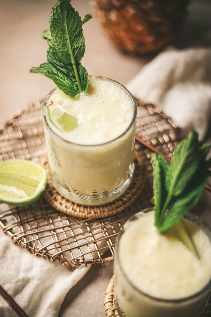Two pina colada mocktails with lime and mint. 