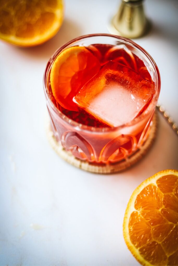 An Aperol negroni with two halves of an orange. 