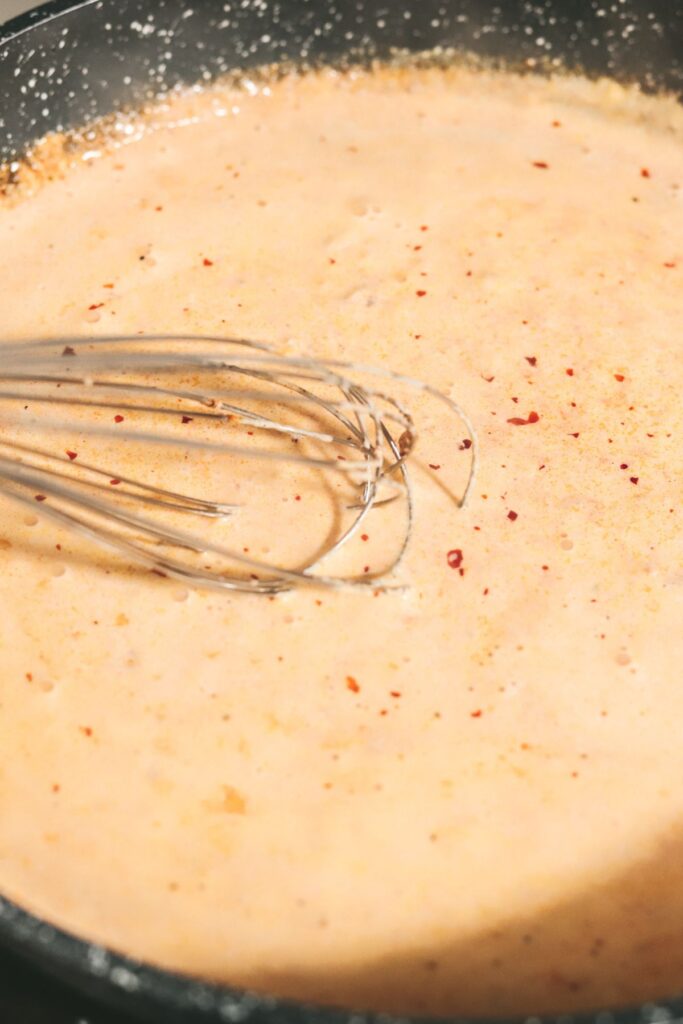 Whisking the nduja sausage in the cream. 