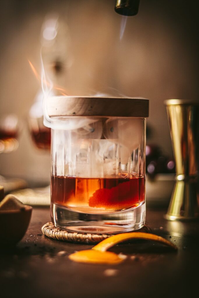 An old fashioned being smoked with a kitchen torch. 