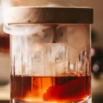 A photo of an old fashioned cocktail being smoked.