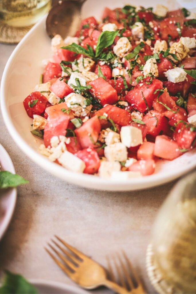 A platter full of watermelon basil salad with feta cheese. 