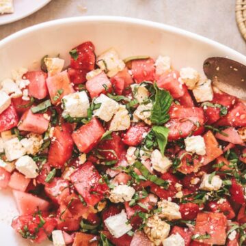 Watermelon basil salad with white wine and serving spoon.