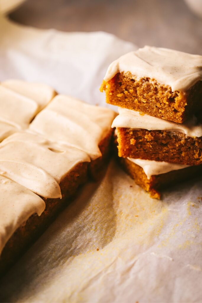 Pumpkin blondies with cream cheese frosting, stacked. 