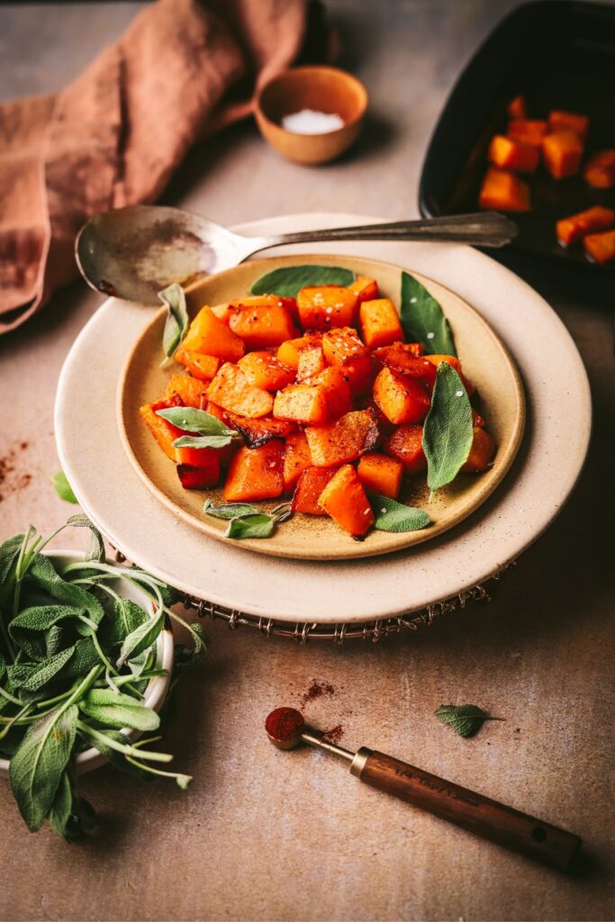 A plate of maple roasted butternut squash with sage - a perfect, easy Thanksgiving side dish. 