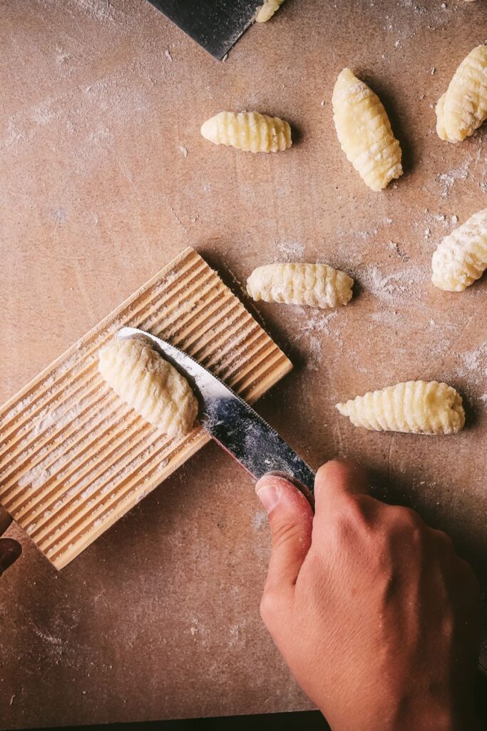 Shaping gnocchi with a board. 