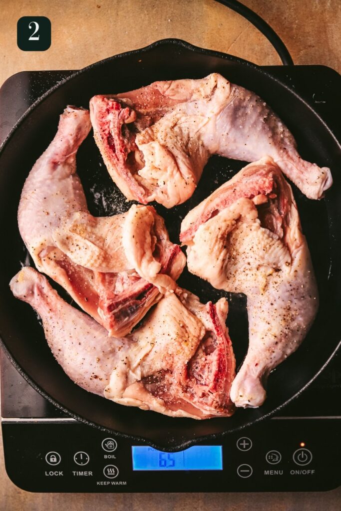Browning chicken thighs and legs in a cast iron skillet.