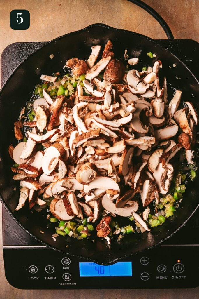 Adding the mushrooms to the pan, and cooking them down. 