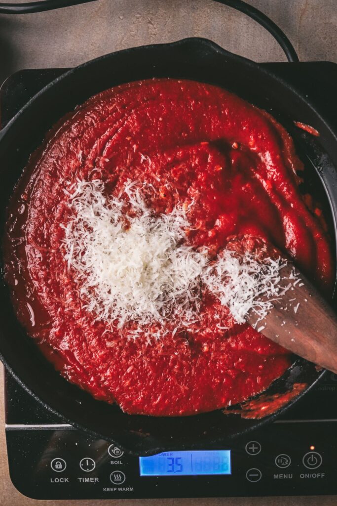 Adding passata and parmesan, stirring. Add mozzarella at this point. 