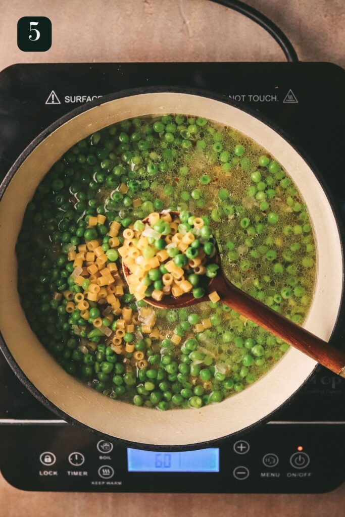 Adding the ditalini to the broth and peas. 