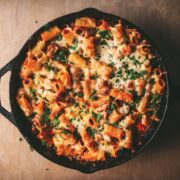 A skillet filled with pasta al forno, baked pasta with sausage and mozzarella cheese.